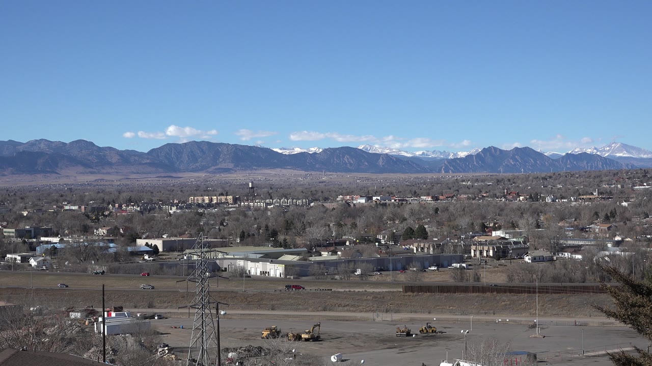 Suburban landscape with power tower and mountain backdrop
