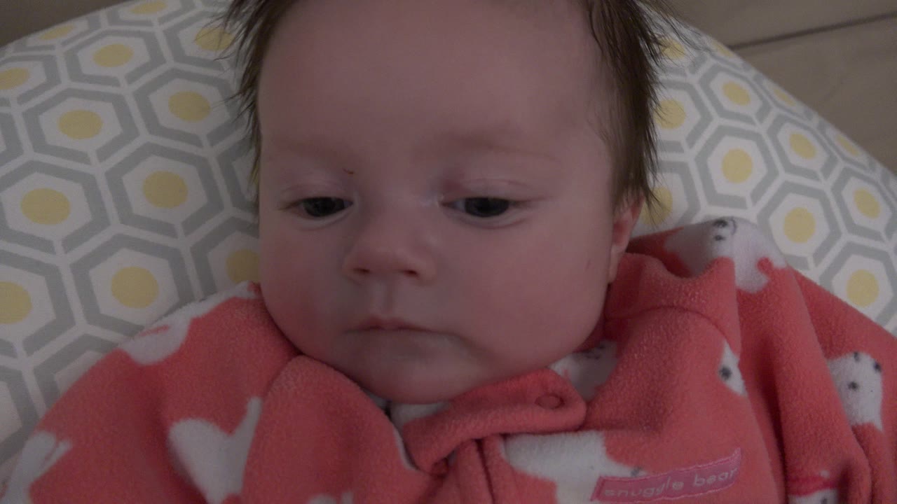 Close view of a baby on a patterned cushion.