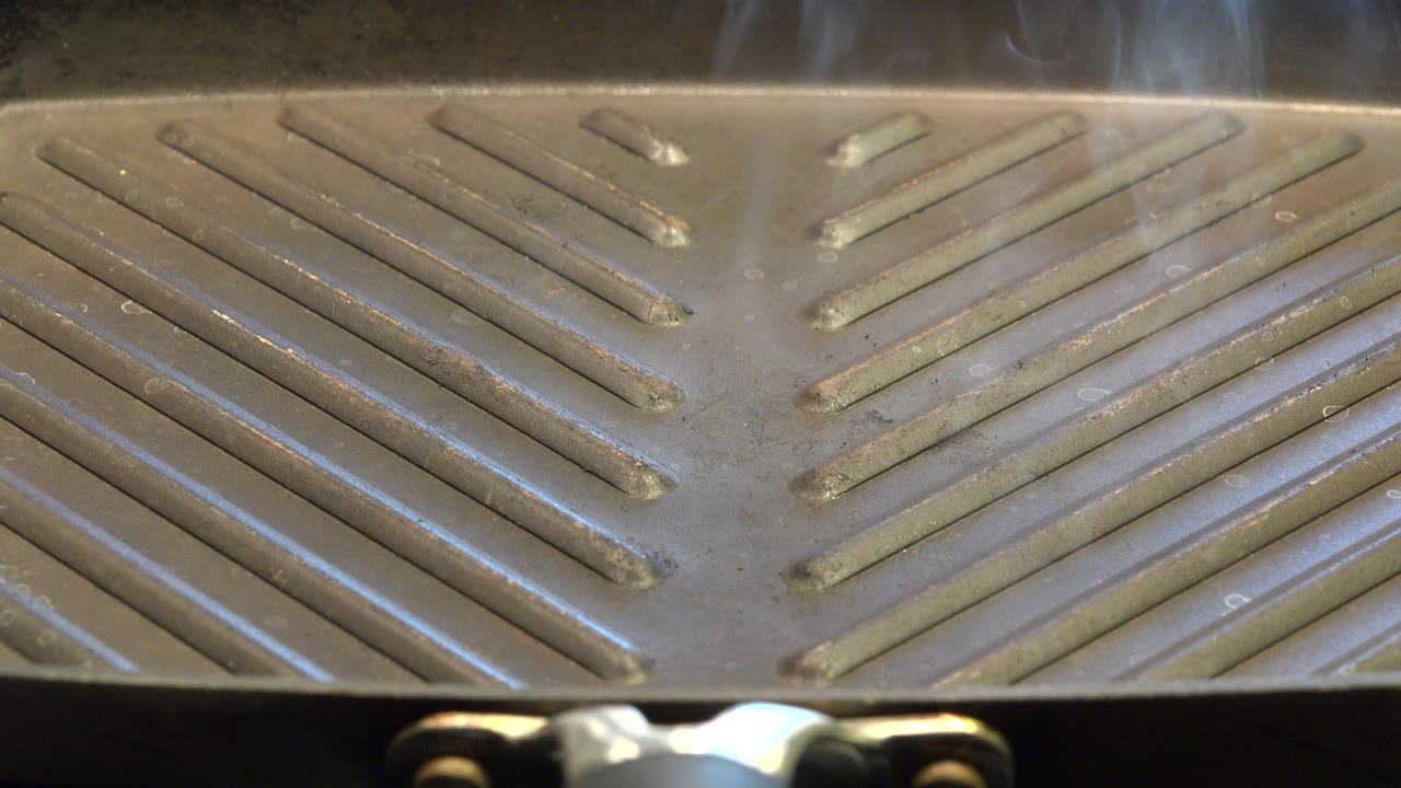 Close view of a smoking gray grill surface.
