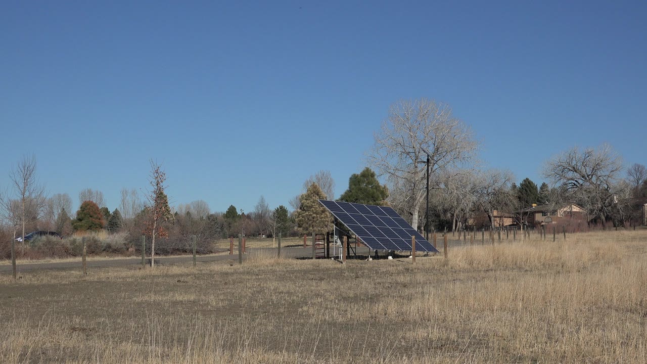 Solar panel in a dry field under a clear blue sky