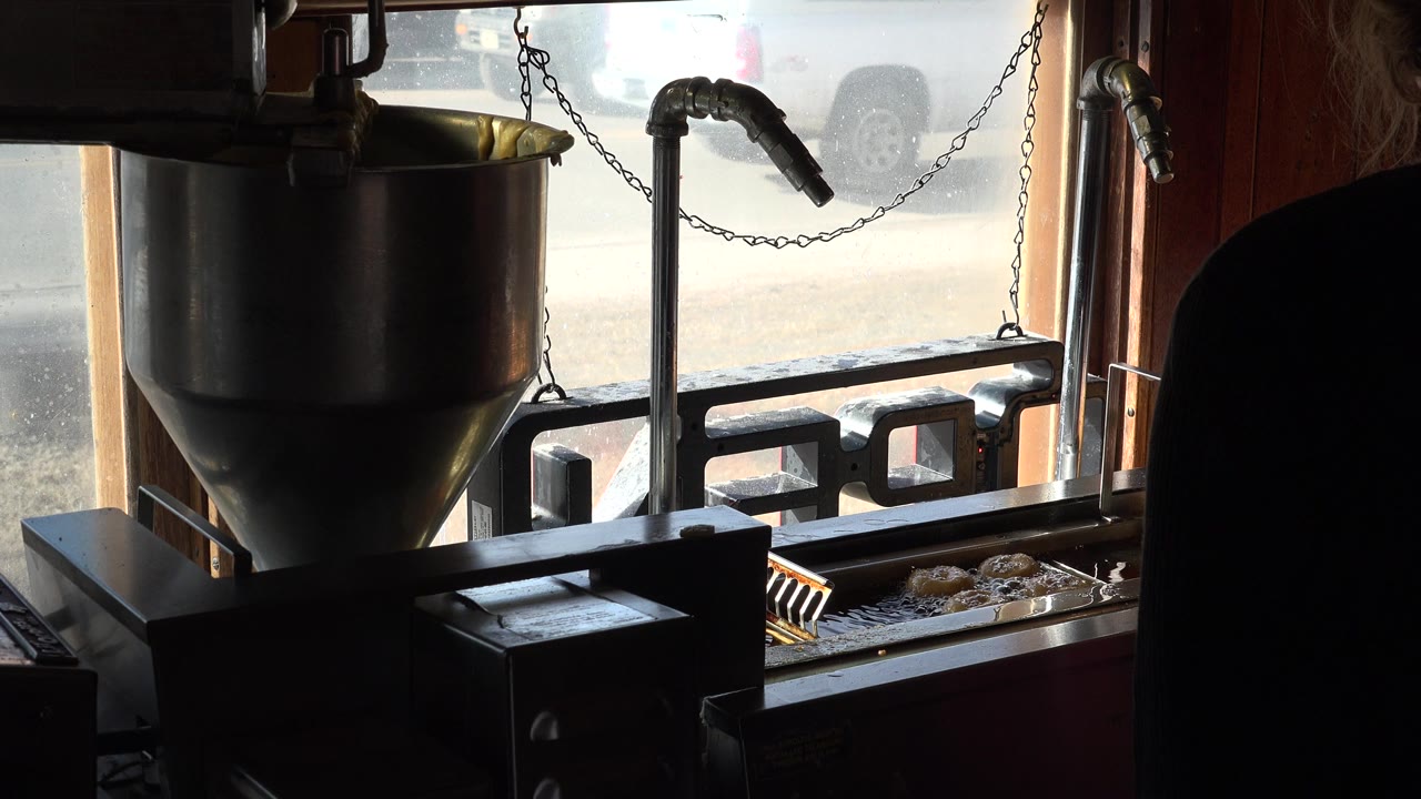 Fryer machine by a window with a vehicle shape visible outside.
