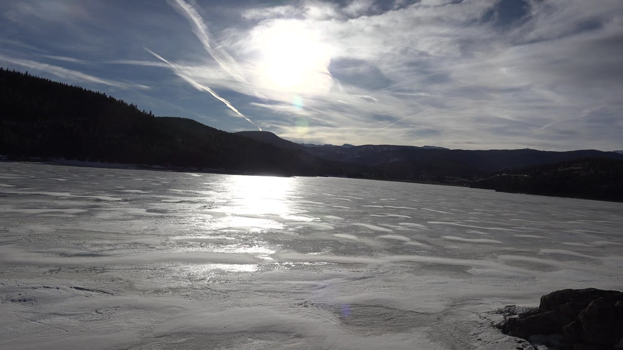 Frozen lake and mountain horizon with bright backlight.