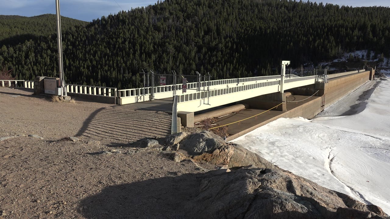 Road bridge and frozen river with rocks in the foreground