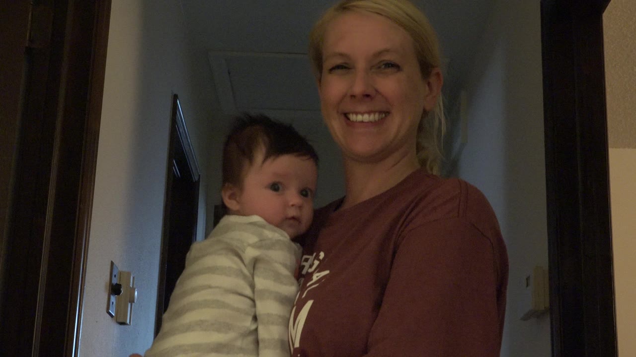 In Westminster, Colorado, the woman remains smiling in the doorway as the baby looks slightly to the side from her arms.