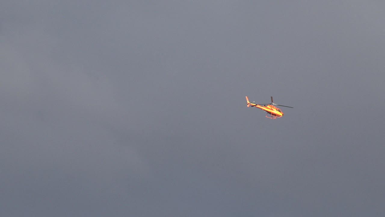 Helicopter near the upper right of gray sky
