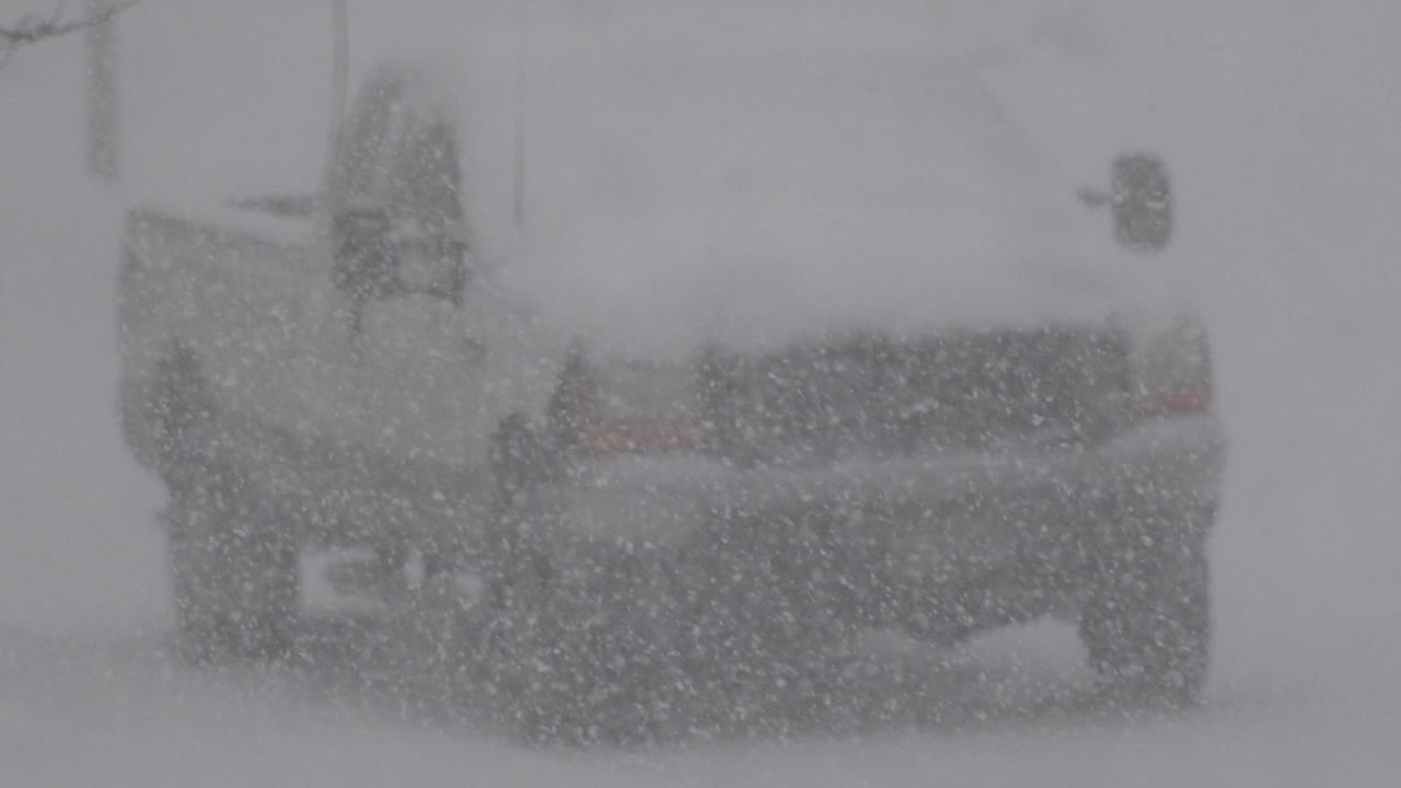 At 0:00, the rear of a snow-covered vehicle is partly visible in Westminster, Colorado, with heavy snow across the frame and no visible people.
