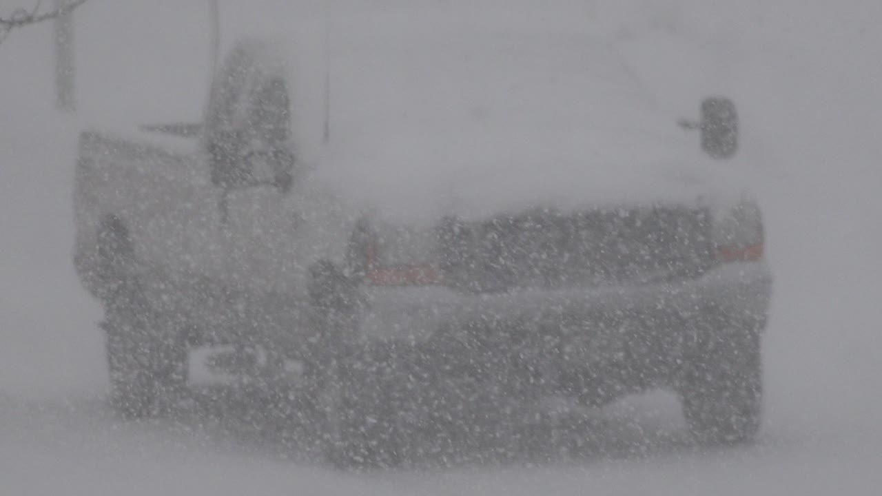 At 0:01, the vehicle rear remains centered as dense snowfall obscures the background in Westminster, Colorado, with no visible people.