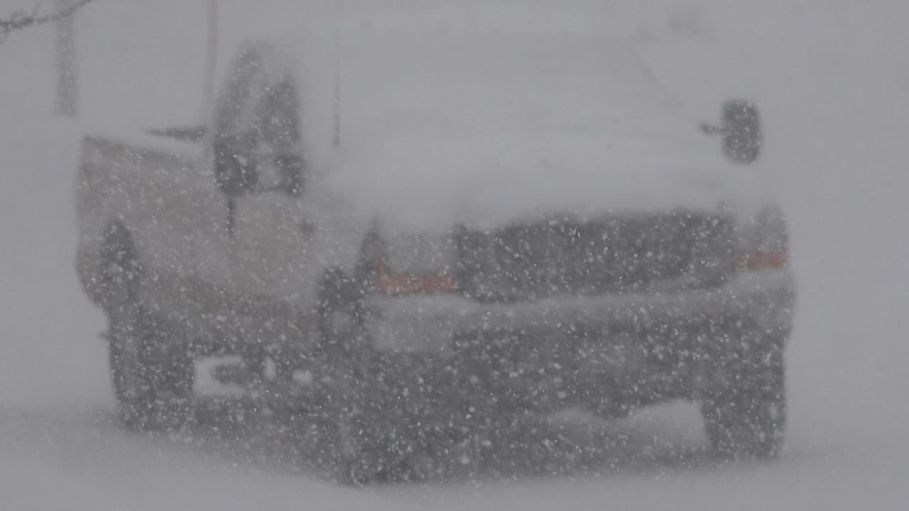 Rear corner of a vehicle coated in snow.