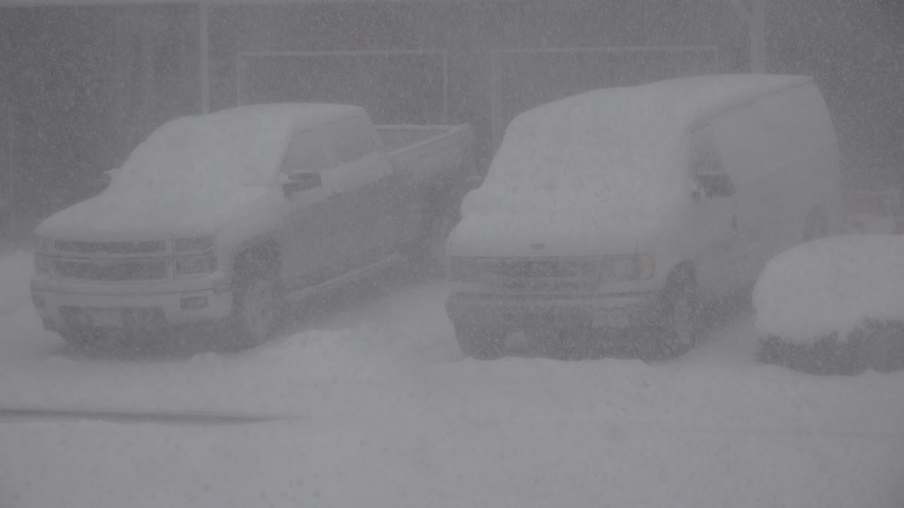 Snow-covered pickup truck and van parked side by side.