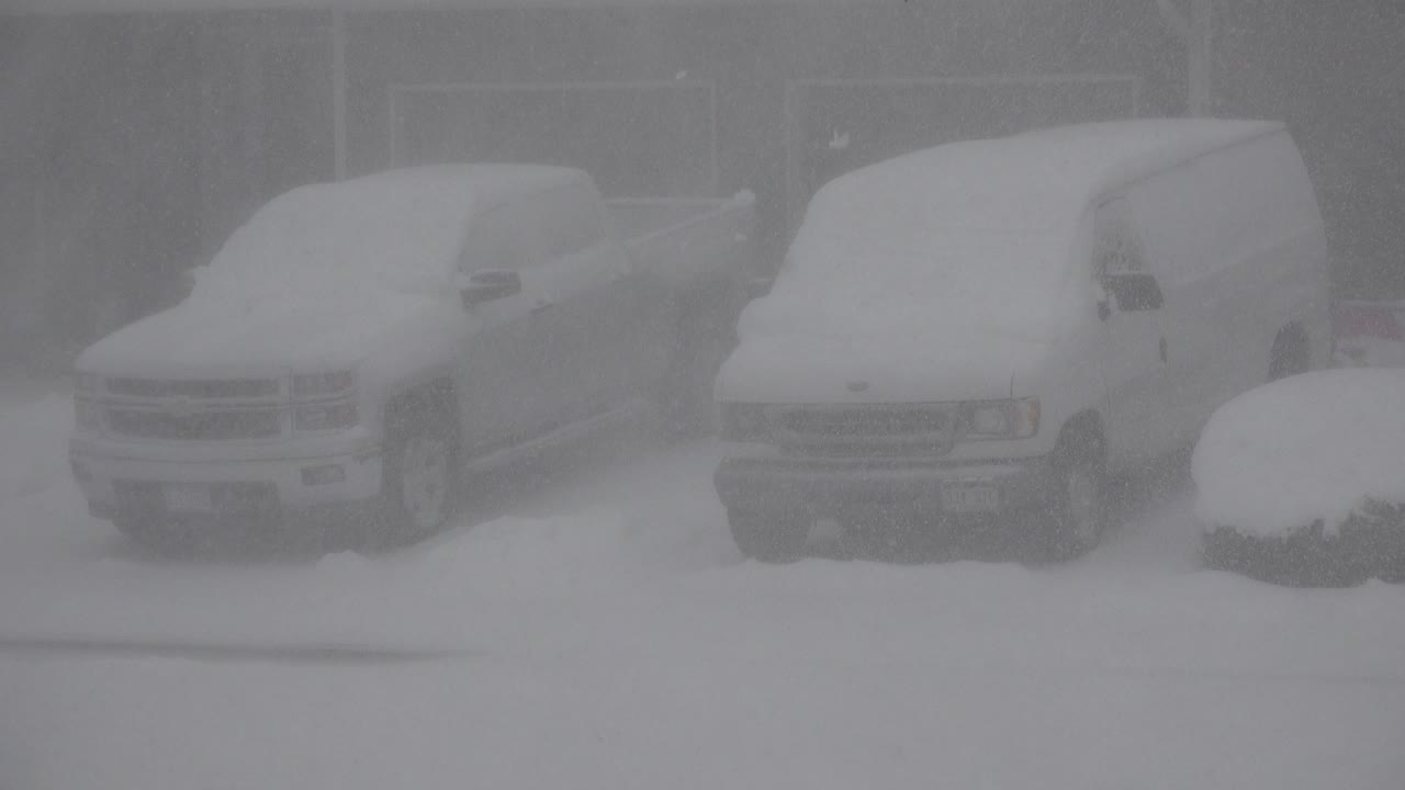 Snow-covered pickup and cargo van in heavy snowfall