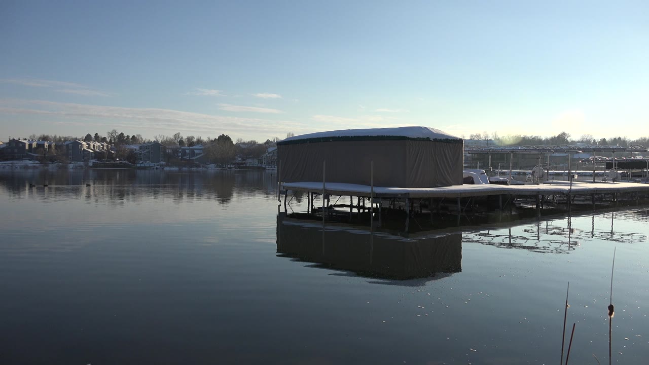 Covered dock over calm winter lake water
