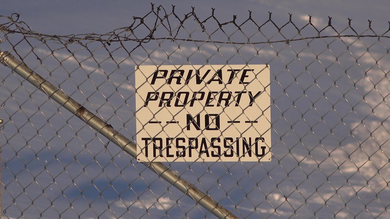Close view of a private property sign on a chain-link fence