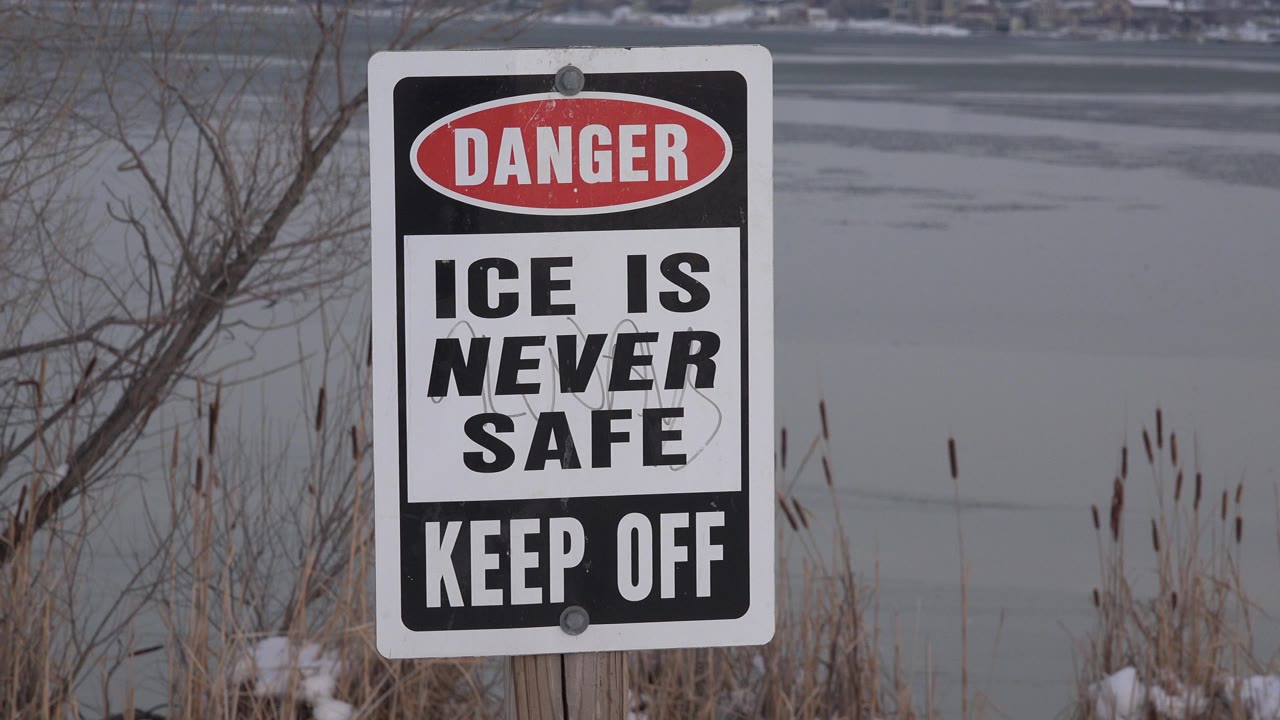 Danger sign beside a frozen pond in snow.