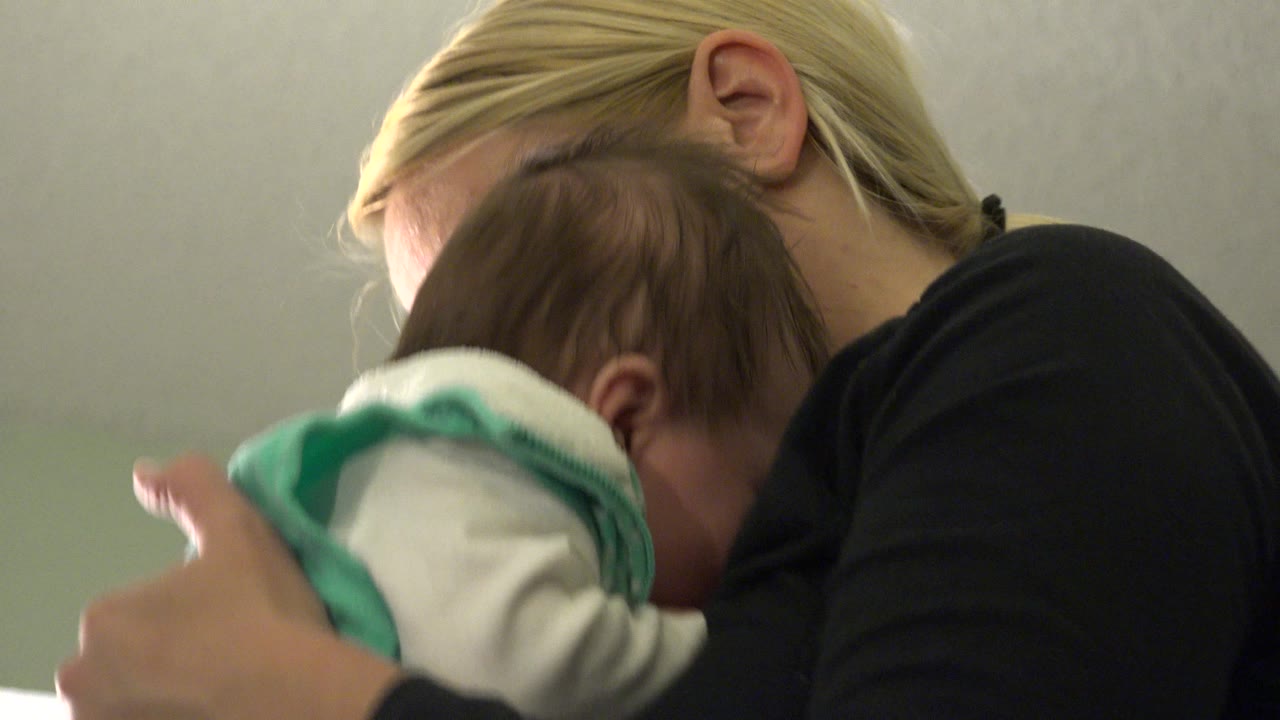 In Westminster, Colorado, the woman's head tilts down toward the baby as the infant rests against her chest near the center of the frame.