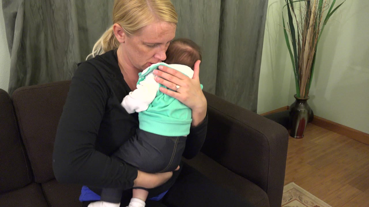 Mother pressing her face close to a baby she is holding.