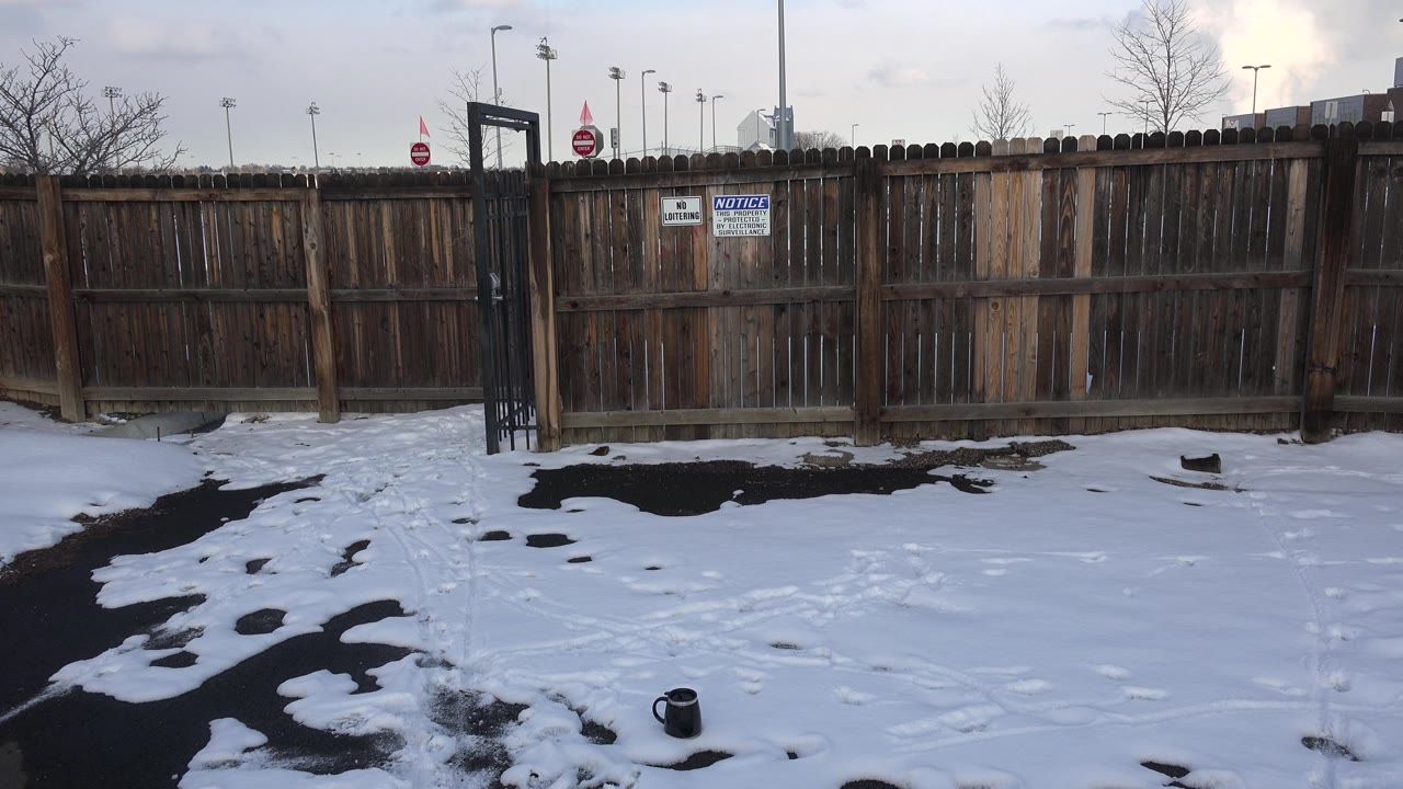Weathered wooden fence and snowy foreground under cloudy sky
