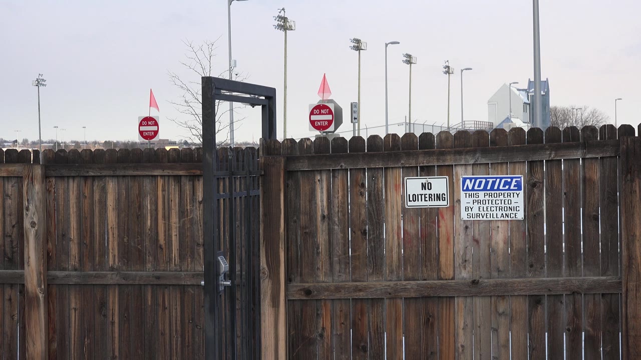 Private property notice on wooden fence with red do not enter signs above.