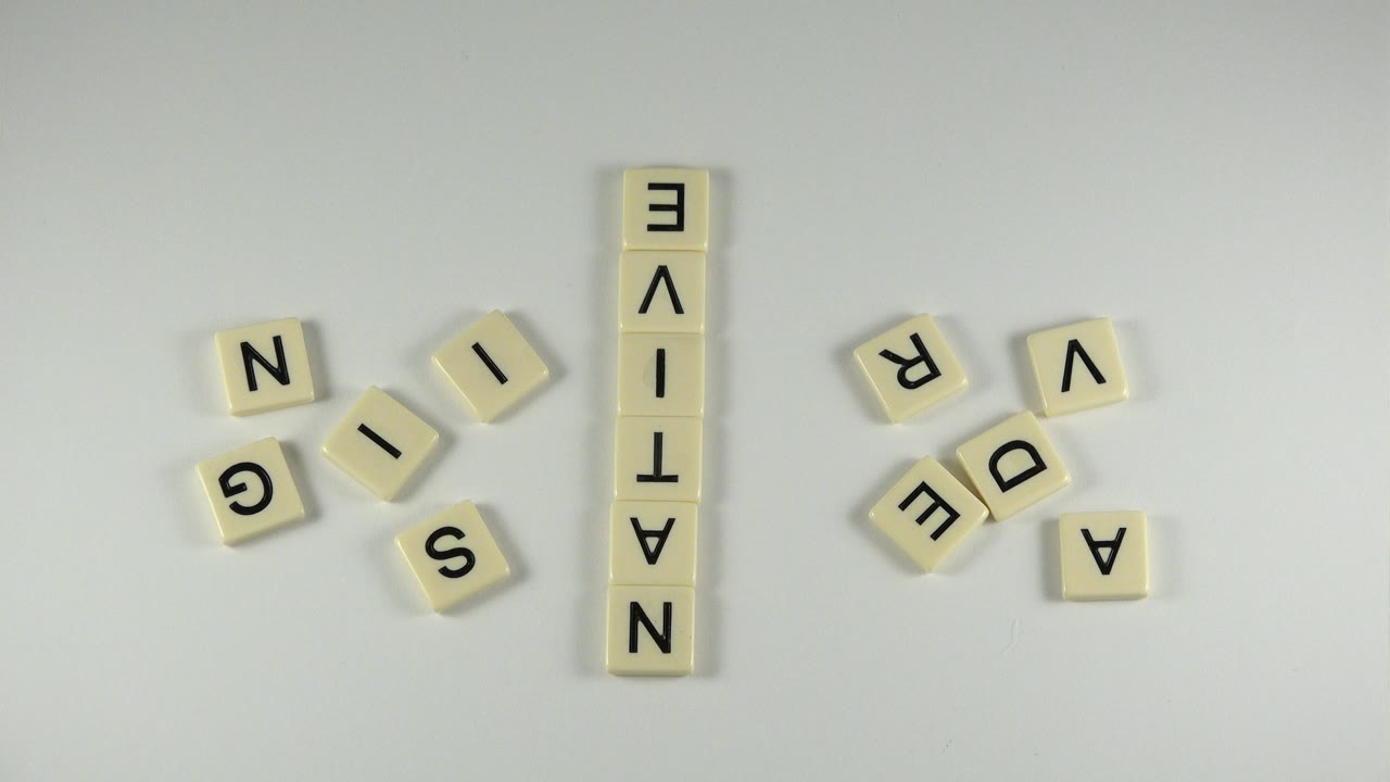 Letter tiles arranged on a pale tabletop with NATIVE spelled vertically.