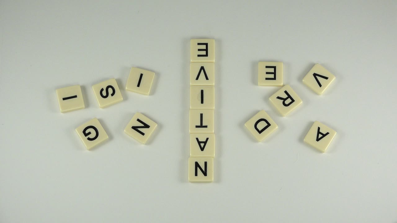 Letter tiles arranged around a vertical word on a pale surface.