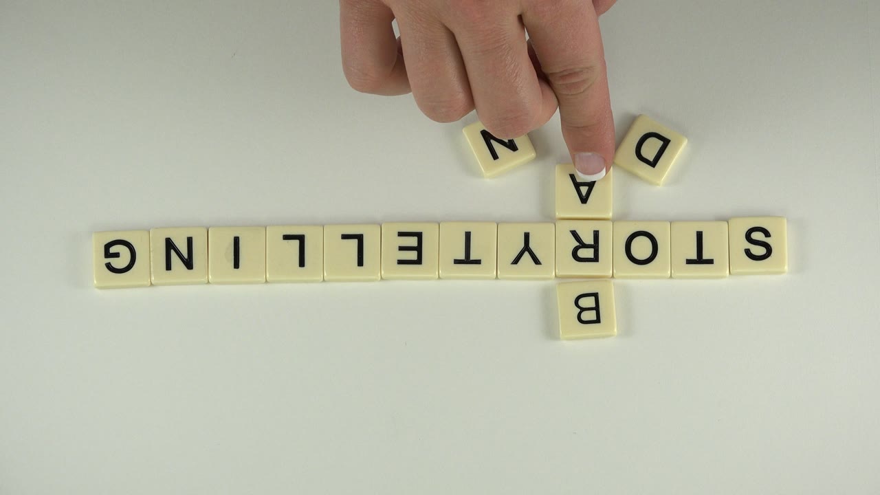 Hand places an A tile above the R in STORYTELLING.