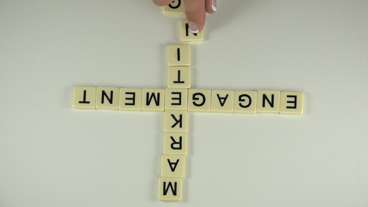 Overhead frame from the Westminster, Colorado clip showing the engagement and marketing tile words crossing at the center on a clean pale surface.