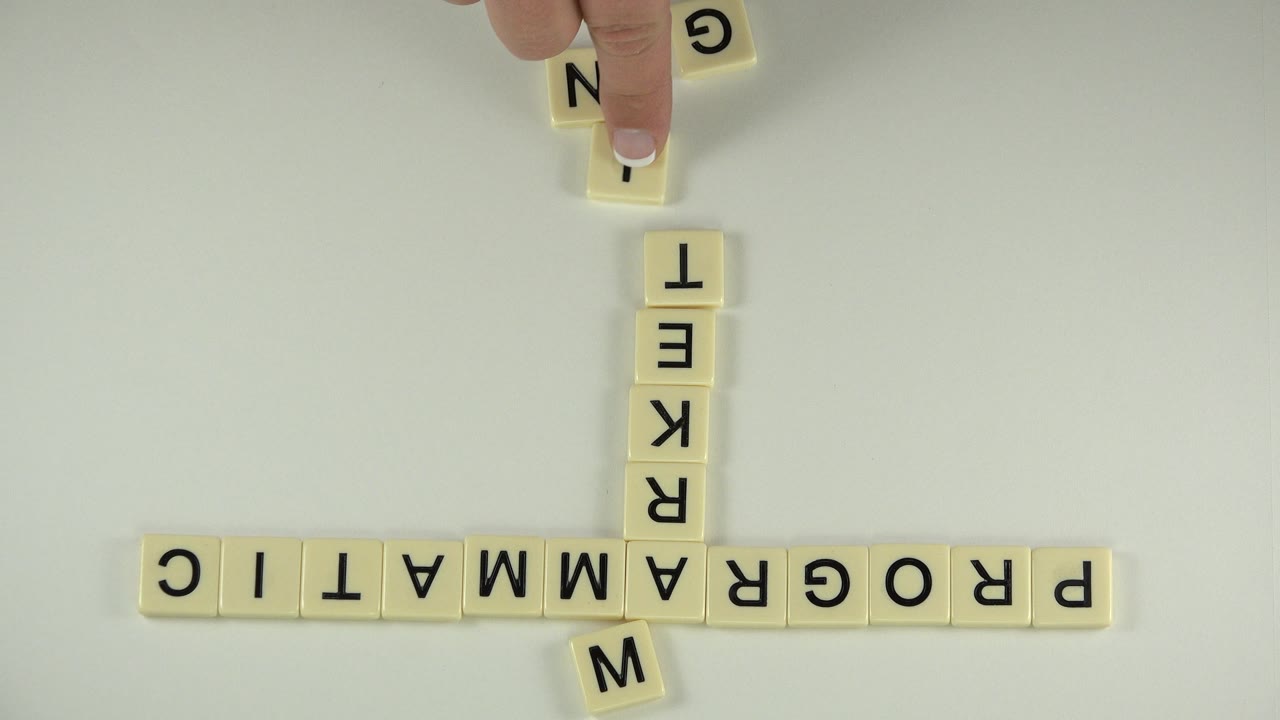 Tiles form PROGRAMMATIC horizontally and a longer vertical word through the center.