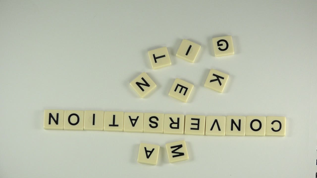 Scrabble-style tiles spelling CONVERSATION on a pale table.
