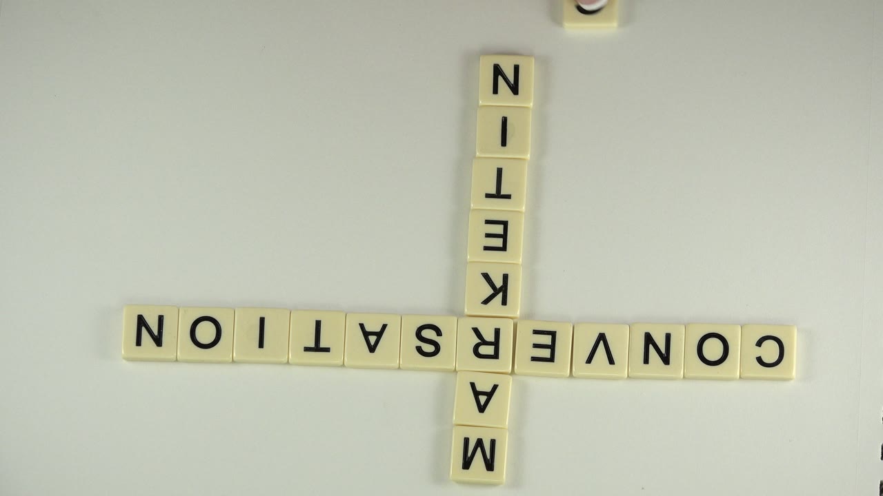 Inverted word tiles arranged as a cross on a blank tabletop.
