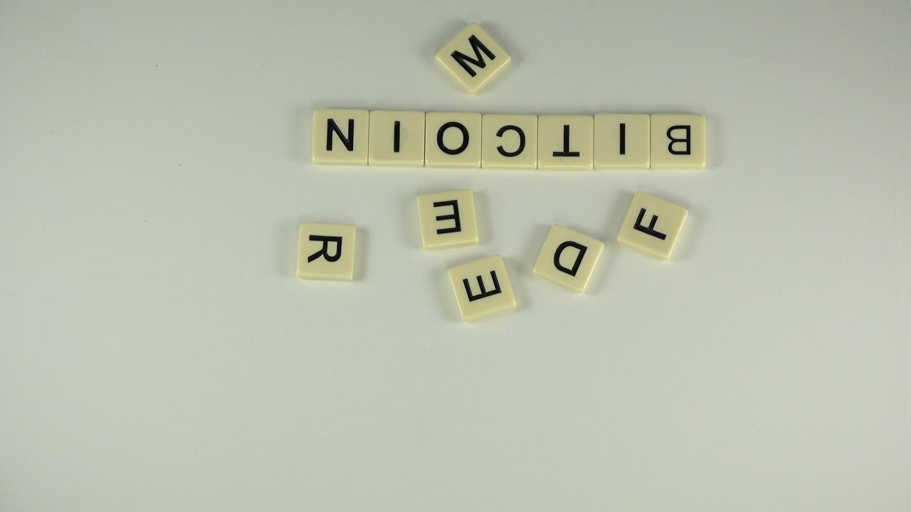 Scrabble-style tiles spelling BITCOIN on a pale tabletop with loose letters below.