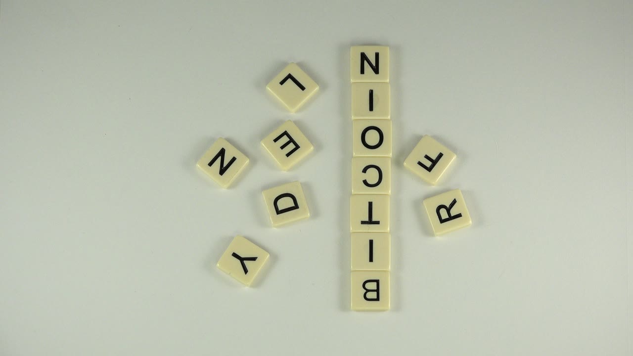 Letter tiles spelling Bitcoin on a pale tabletop.