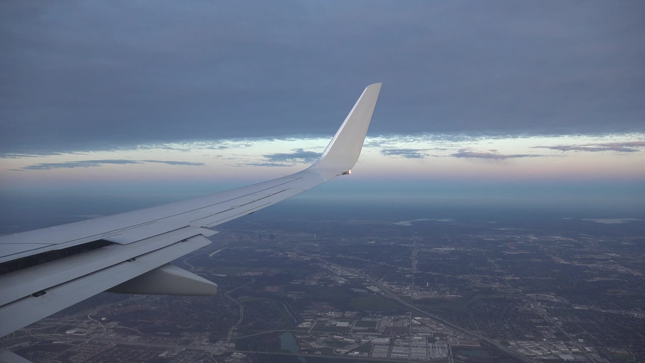 A white aircraft wing extends toward a pale horizon over dark developed terrain in the Playa del Carmen Mexico 2015 collection, with no visible people.