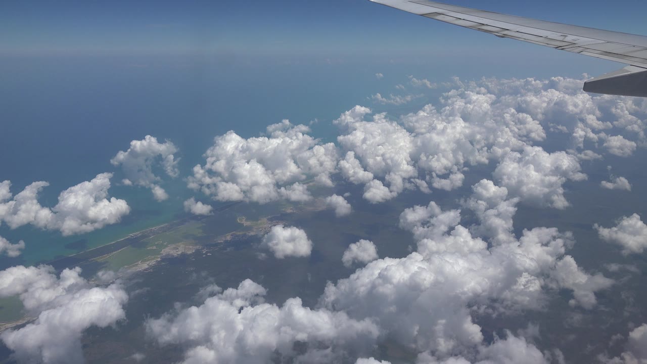 White clouds over ocean and coast from a plane