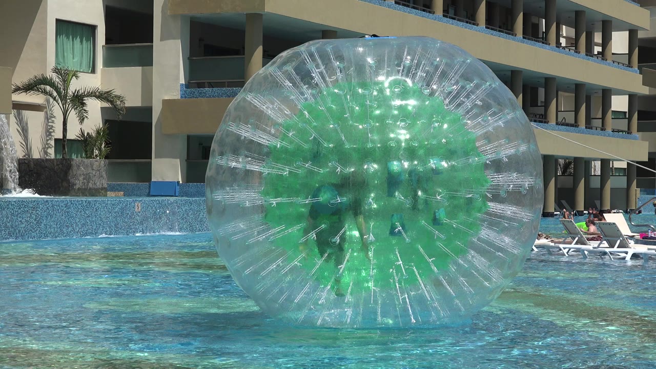 Clear inflatable pool wheel floating in front of resort balconies.