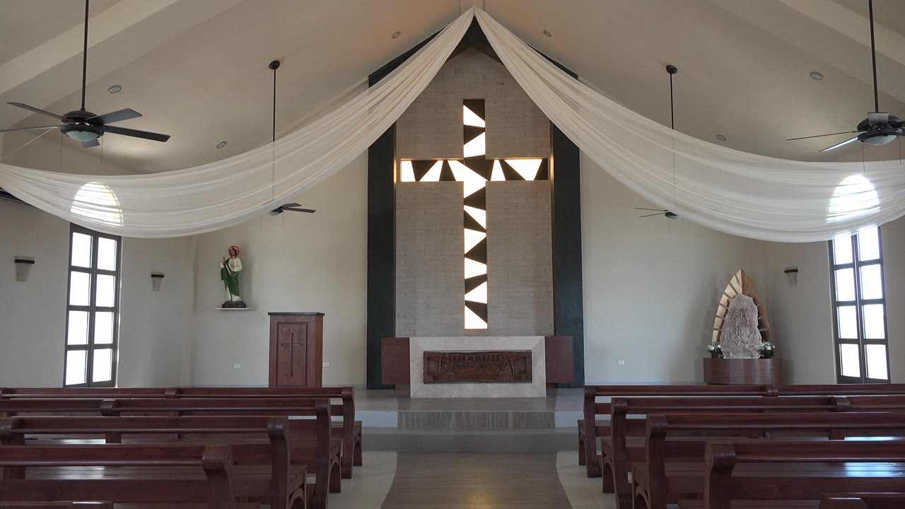 Empty pews and altar wall with black and white cross pattern