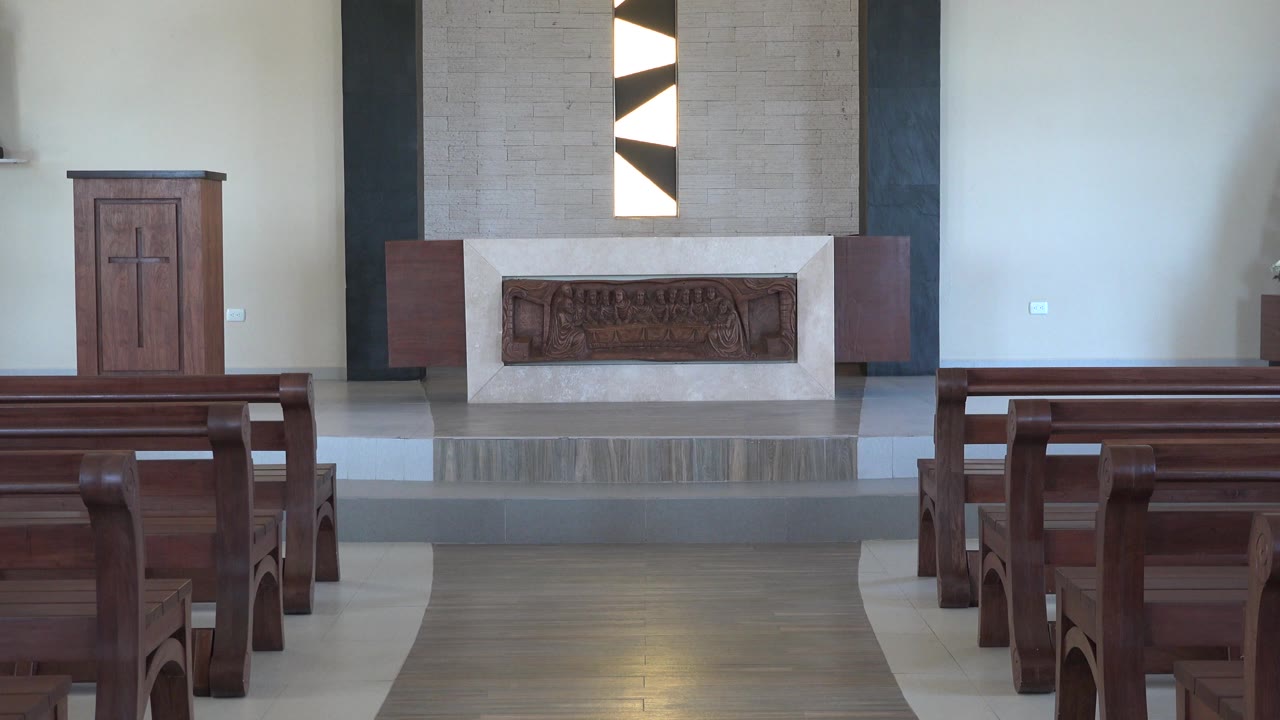 Second frame shows more of the central aisle and altar front in the Playa Del Carmen church, with the geometric wall feature above and no visible people.