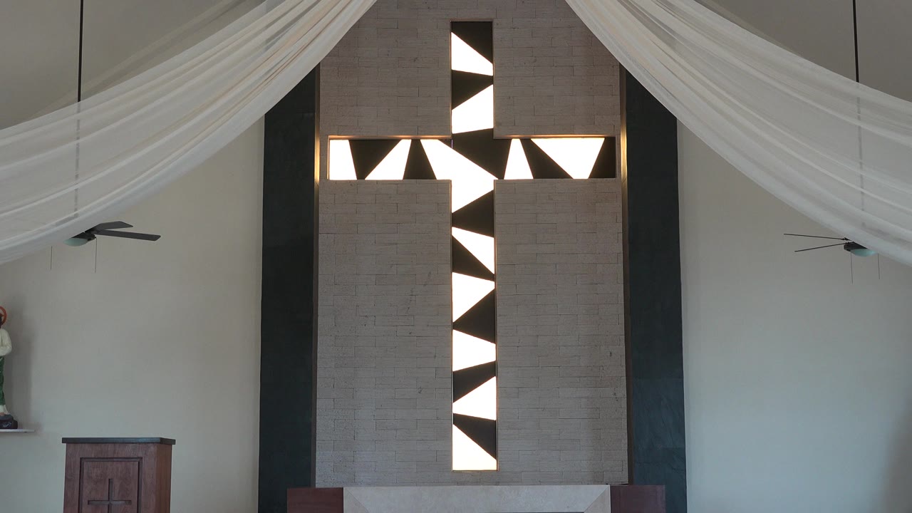 Black and white church cross feature beneath draped white fabric.