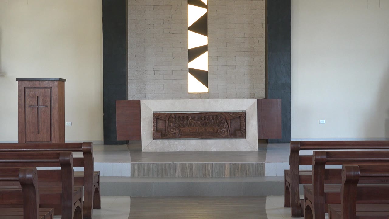 Church interior with pews facing an altar and lectern.