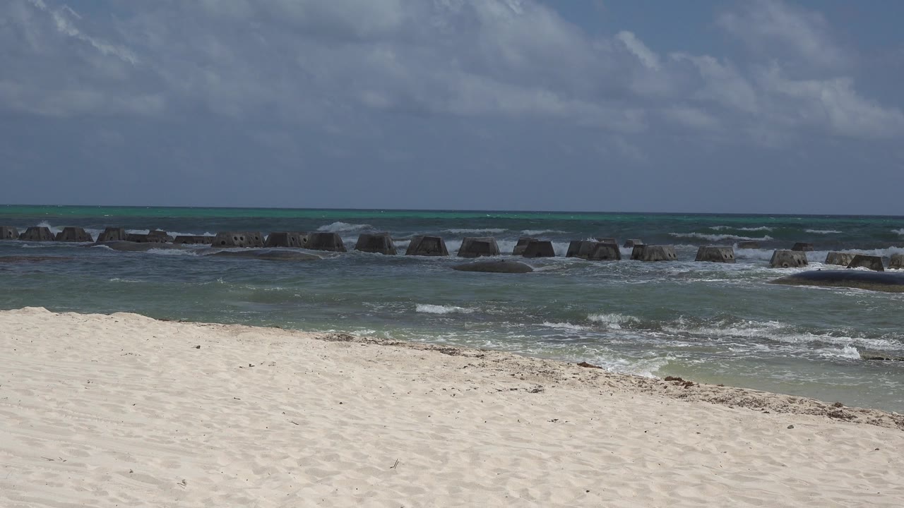 Turquoise water and low surf beyond a sandy beach