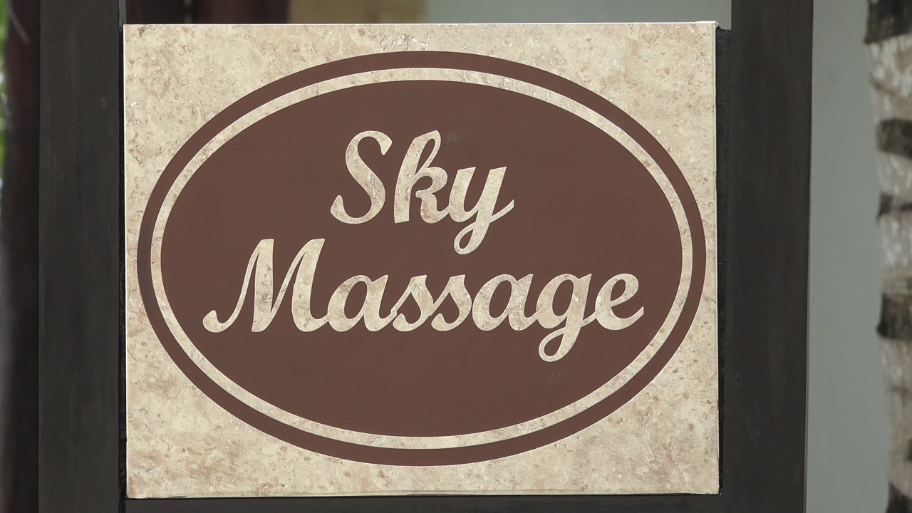 Close view of a Sky Massage sign between dark vertical posts.