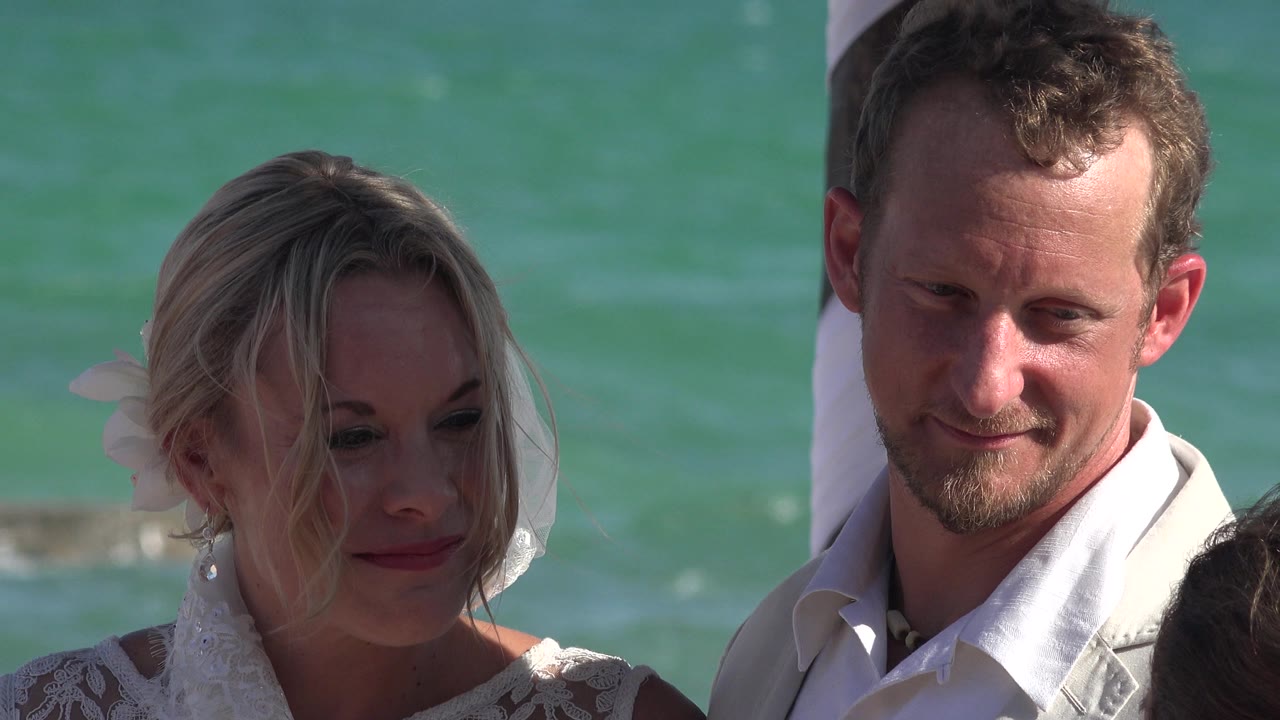 Couple standing close beside turquoise ocean water