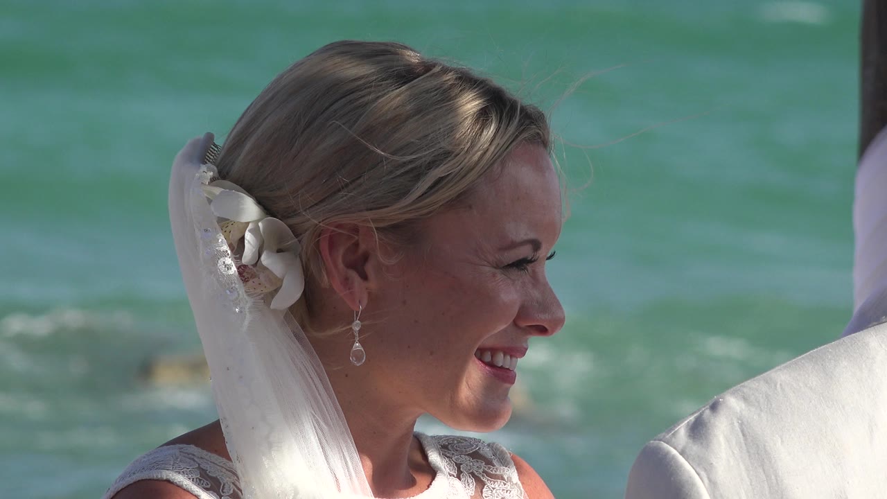 The bride continues smiling in Playa Del Carmen, her veil and hair accessory visible while the groom's shoulder remains cropped on the right edge.