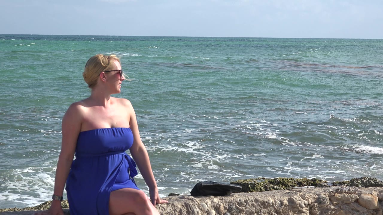 Woman at beach with choppy ocean background.