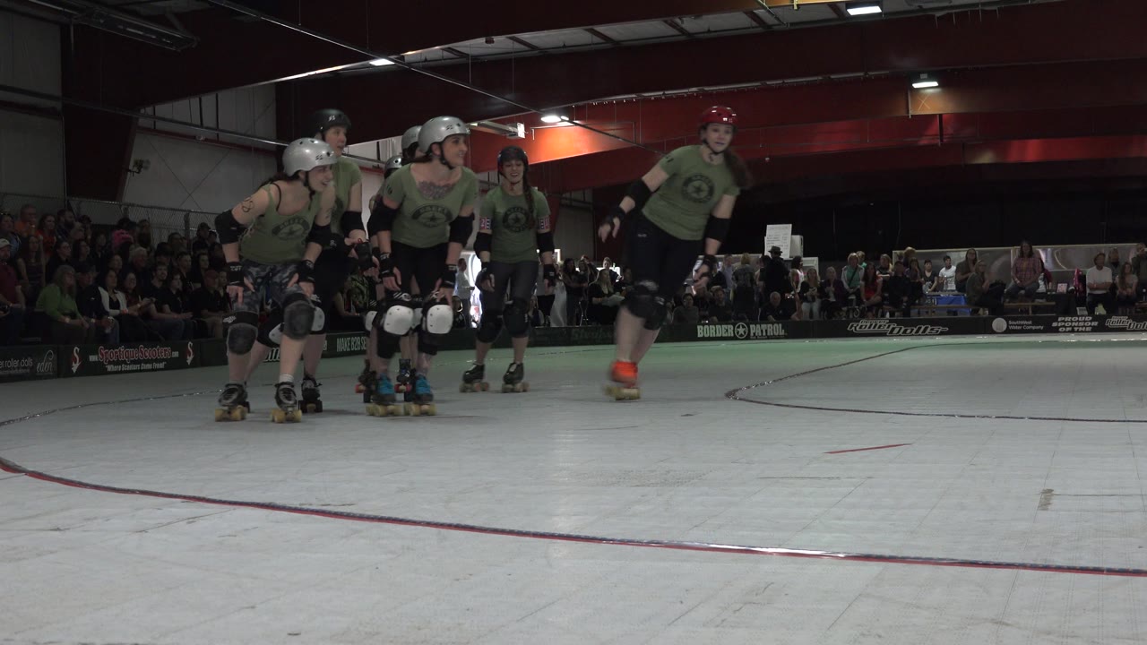 Roller derby team skates past camera near the edge of the track.