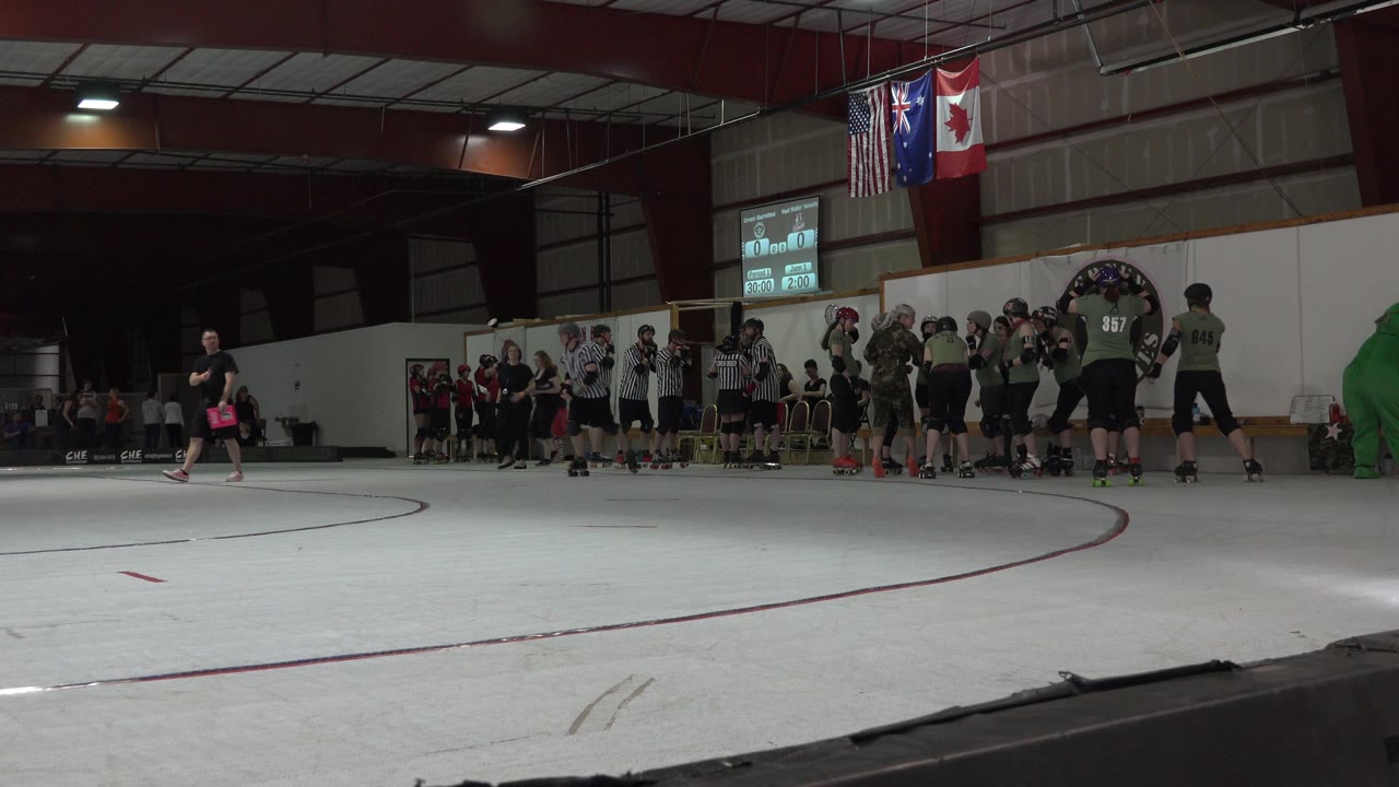 Denver rink frame with a skater moving across the open white floor while helmeted players and striped officials remain grouped along the boards.