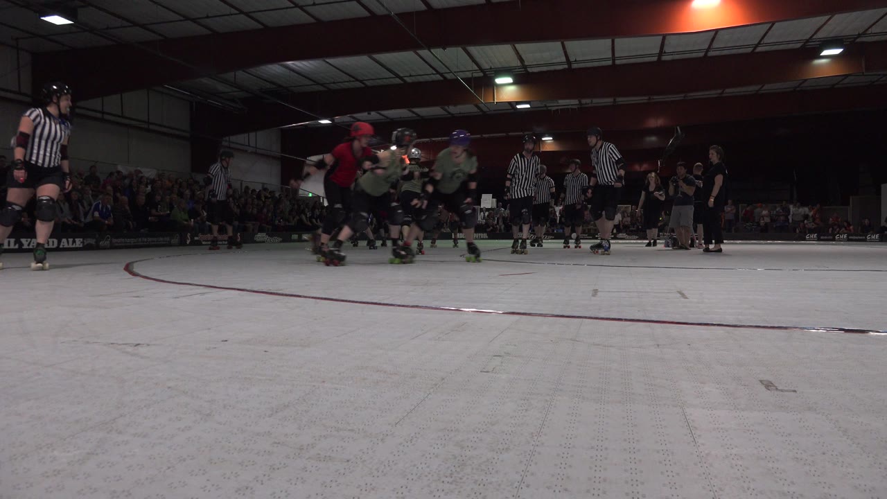 Roller skaters and referees on an indoor track