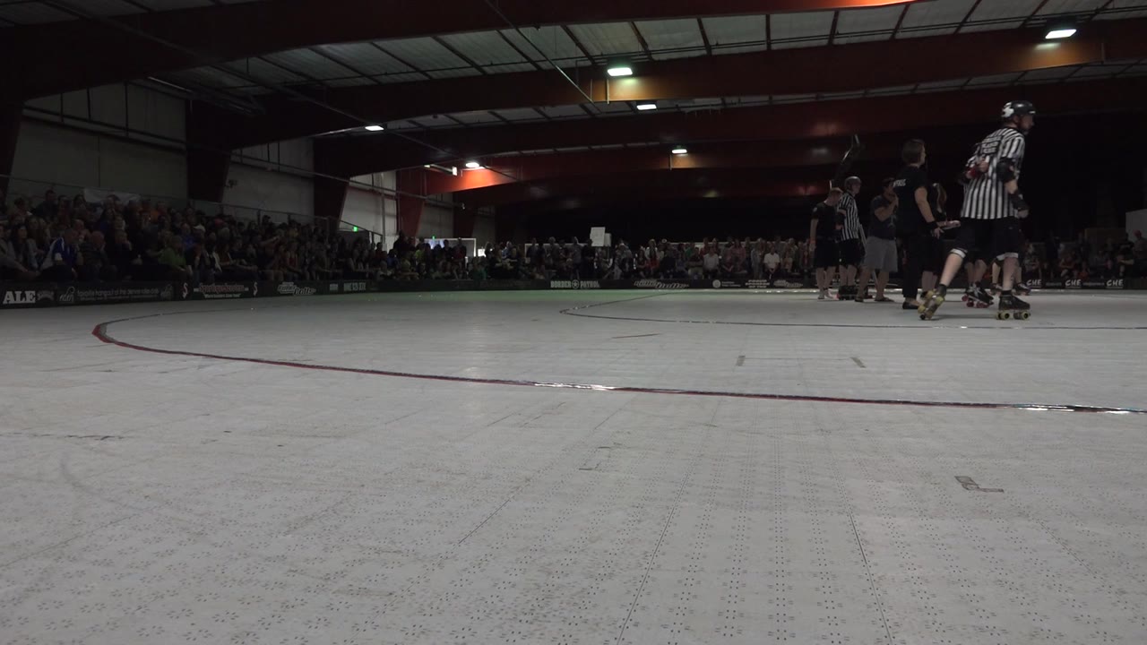 Wide indoor skating rink with skaters moving farther toward the right edge.