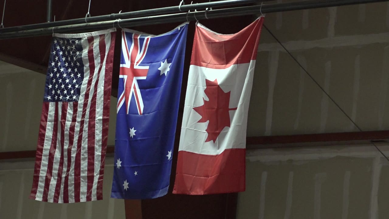 USA, Australia, and Canada flags draped vertically indoors.