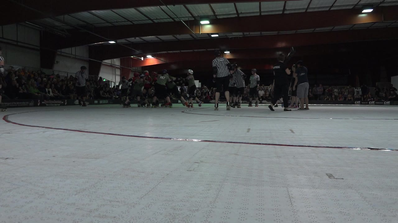 Low rink view of roller derby skaters and referees before action begins.