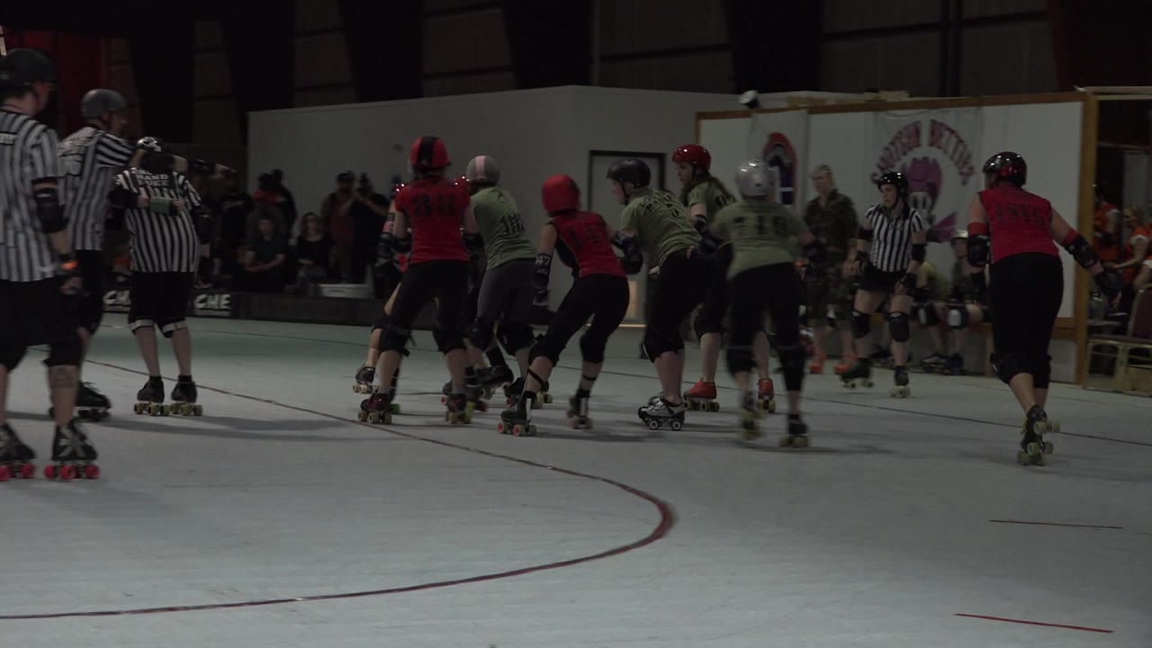 Roller skaters and referees on an indoor sports court.