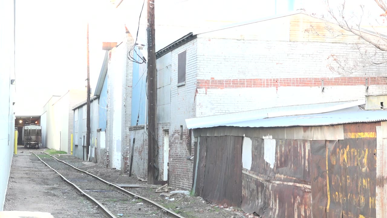 Rail spur passing old industrial facades
